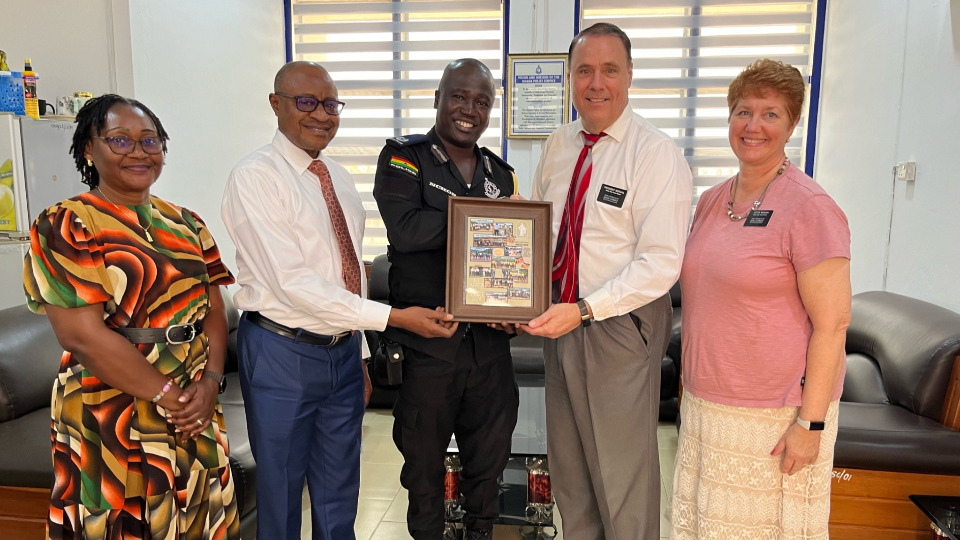 President and Sister Kyungu, along with President and Sister Morgan, present photo collage to Francis Nchor, Assistant Chief of Police for the Ghana Centeral Region, on 5 September 2024.