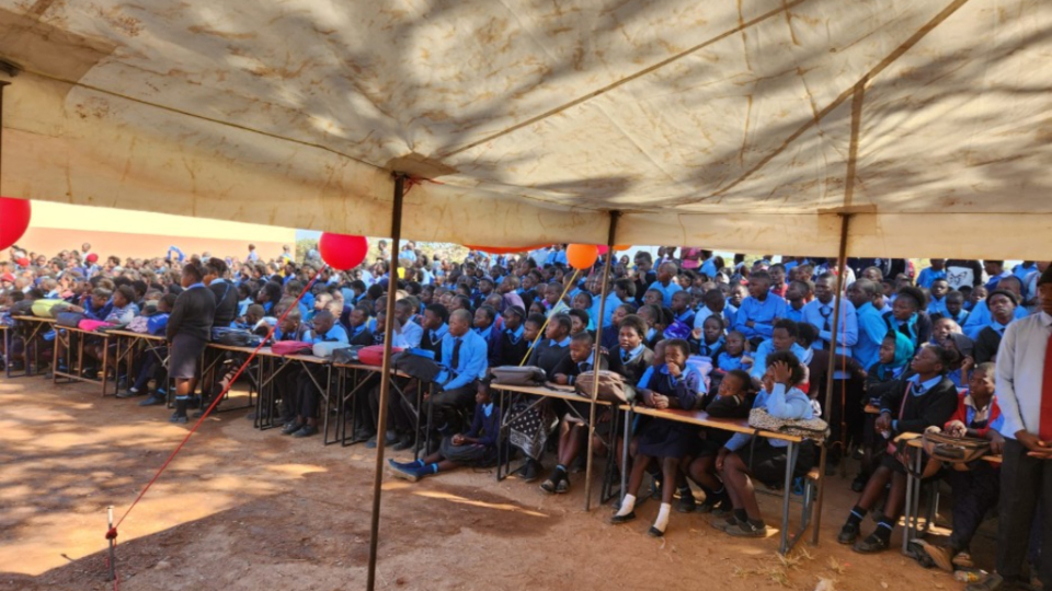 Students-of-Shifwankula-Primary-School-listen-to-speakers-at-the-ribbon-cutting-for-the-new-classrooms.--(Lusaka,-Zambia,-Wednesday,-May-10,-2023).-