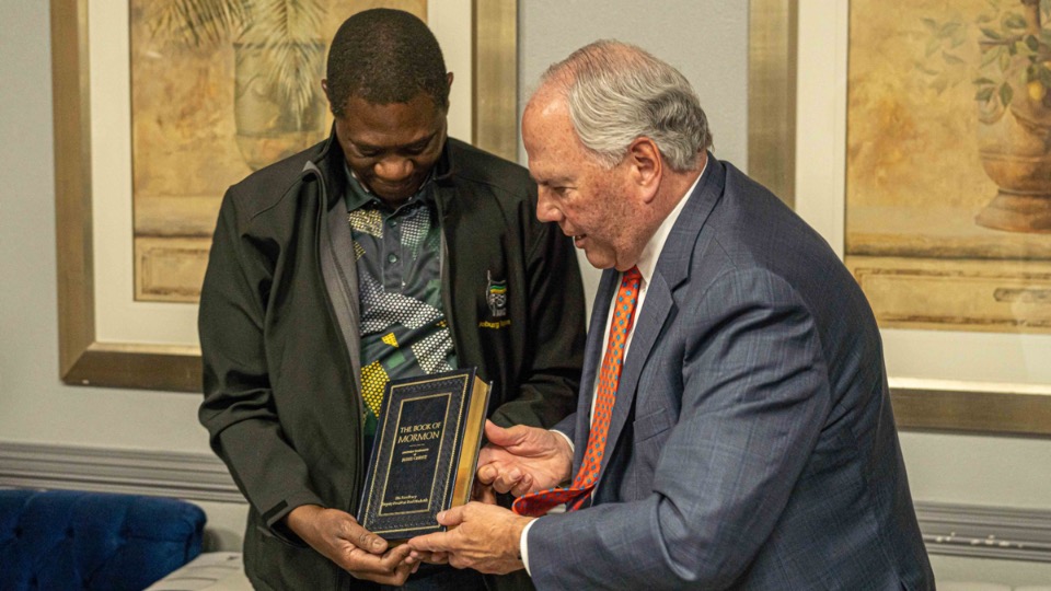 Elder Ronald A. Rasband (right) presents a Book of Mormon to the Deputy President of South Africa, Paul Mashatile (left) (Johannesburg, South Africa, April 22, 2023).
